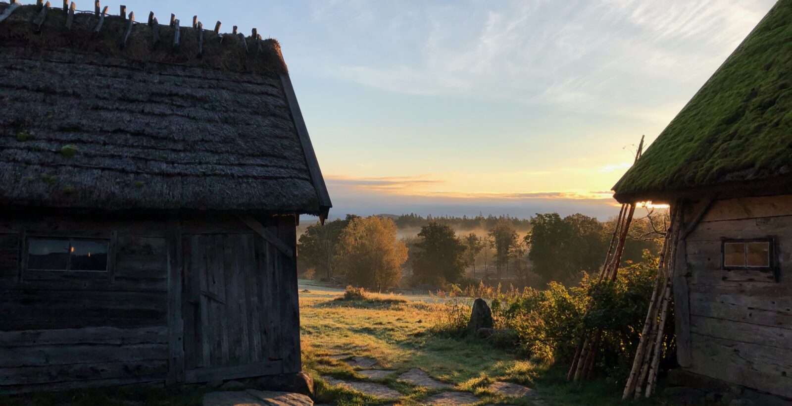 Byggnader, i Äskhults by, i skymmingsljus. Foto.